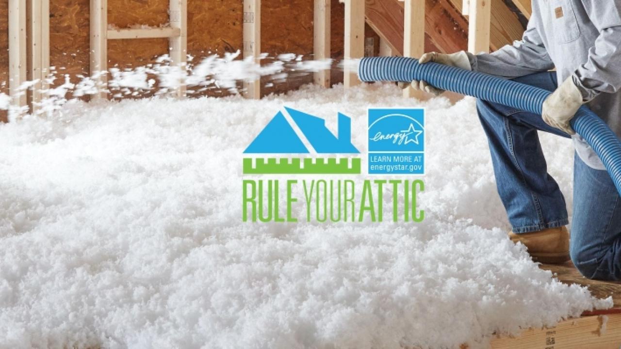 Worker installing insulation in an attic.