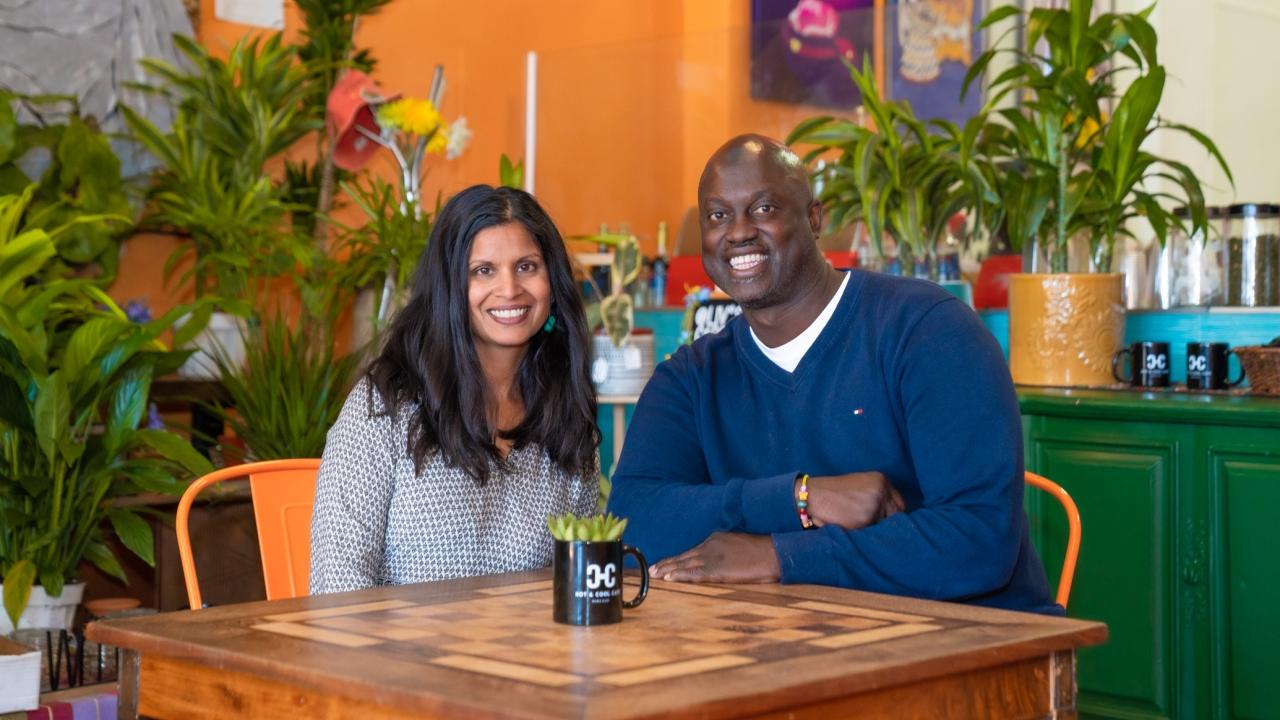 Husband and wife business owners sit at a table in their vegan cafe in Los Angeles.