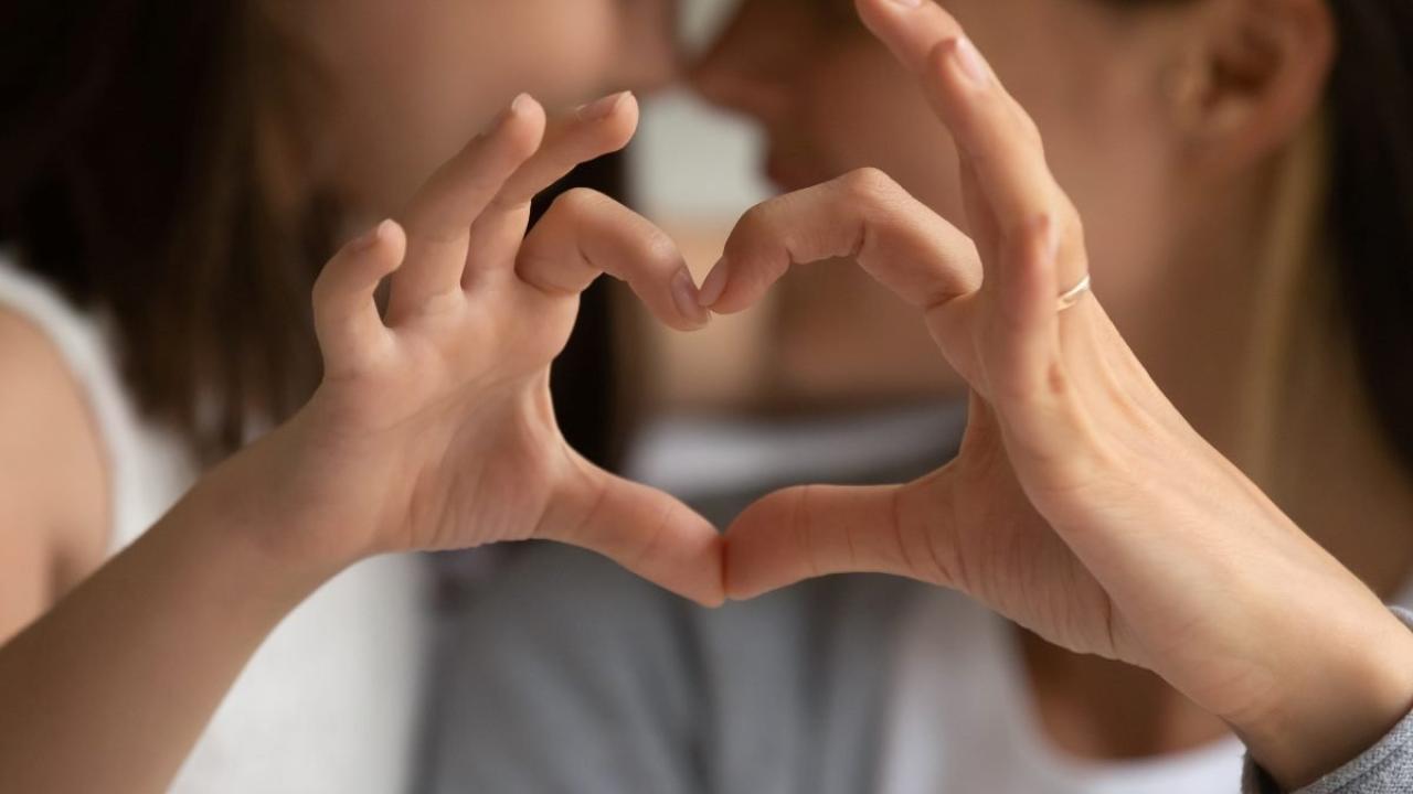 Parent and child making heart shape with hands