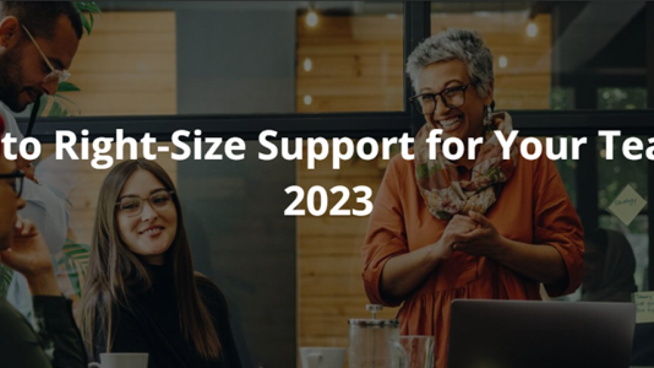 How to Right-Size Support for Your Team in 2023 Blog Image with a team of colleagues working around a desk discussing and smiling.