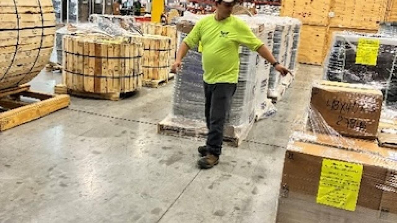Worker in a Wesco warehouse preparing supplies for Hurricane Melissa relief.