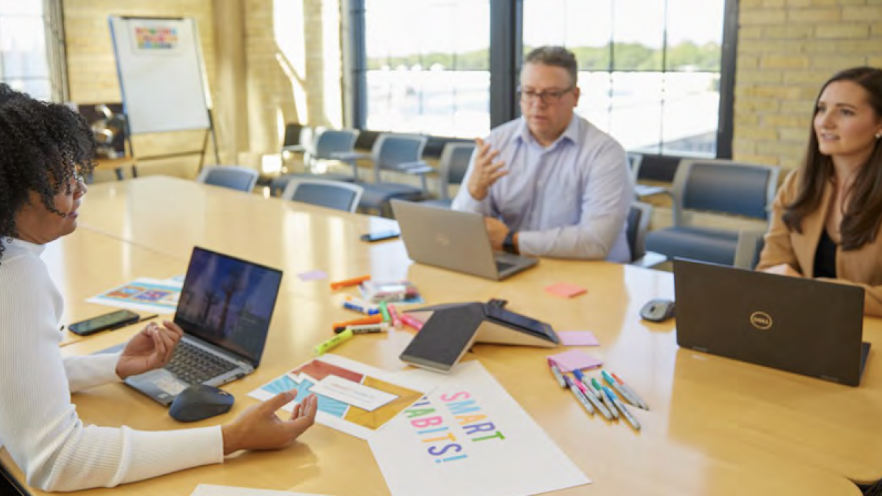 People sat at a table working on laptops