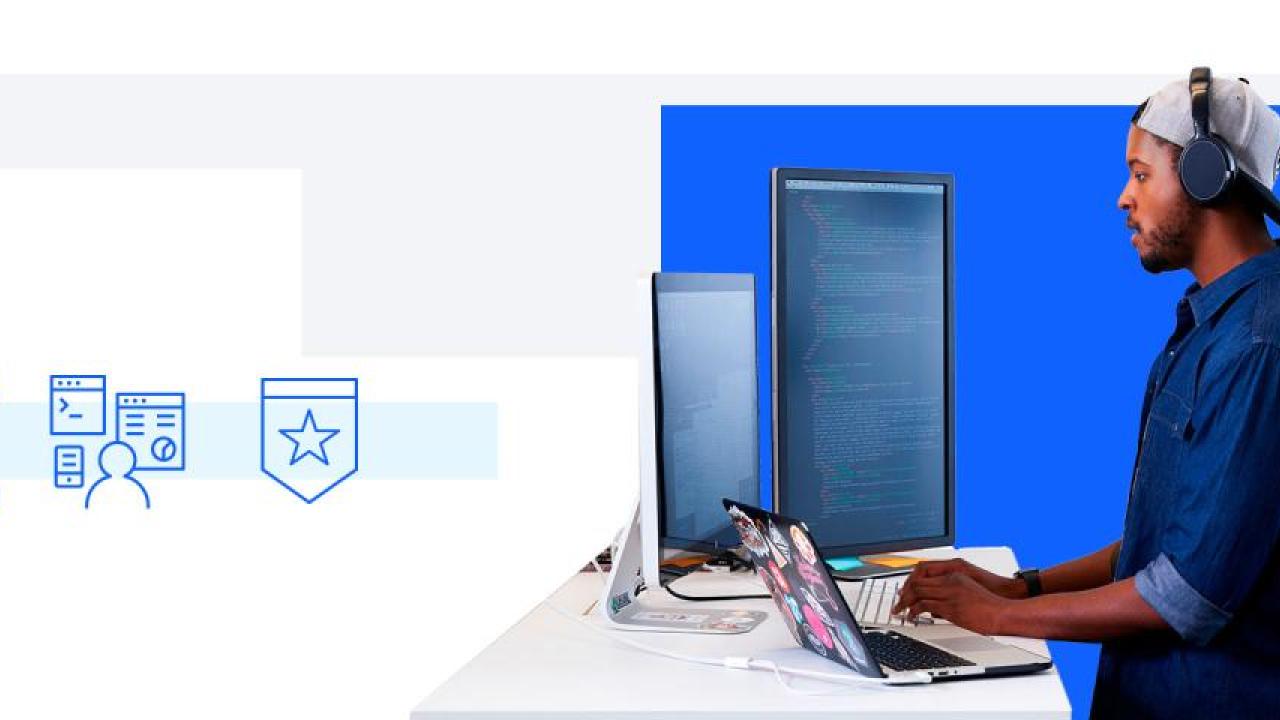 person typing at computer facing multiple monitors