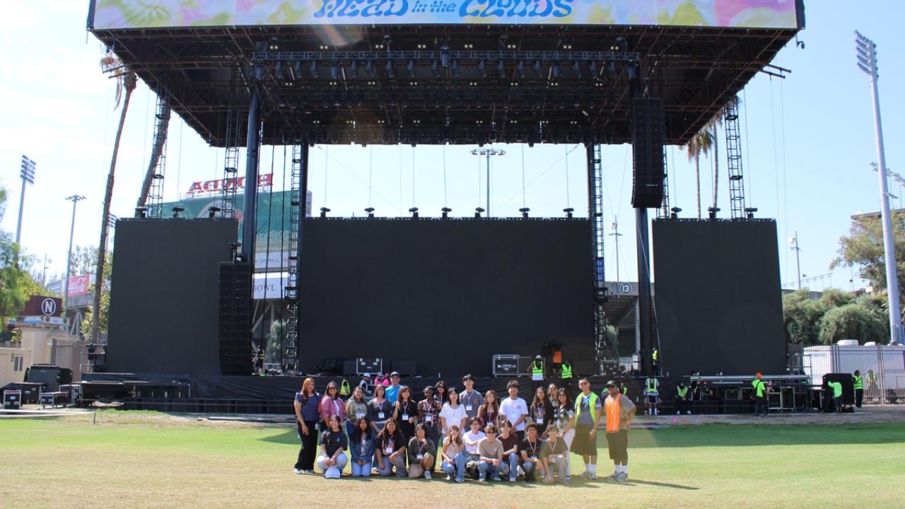 Students and event staff gather in front of the Head in the Clouds main stage during a behind-the-scenes venue tour.