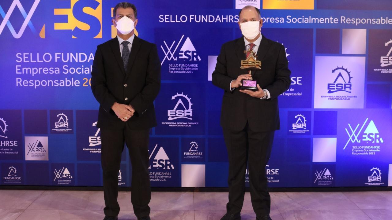Two people holding ESR award on a stage