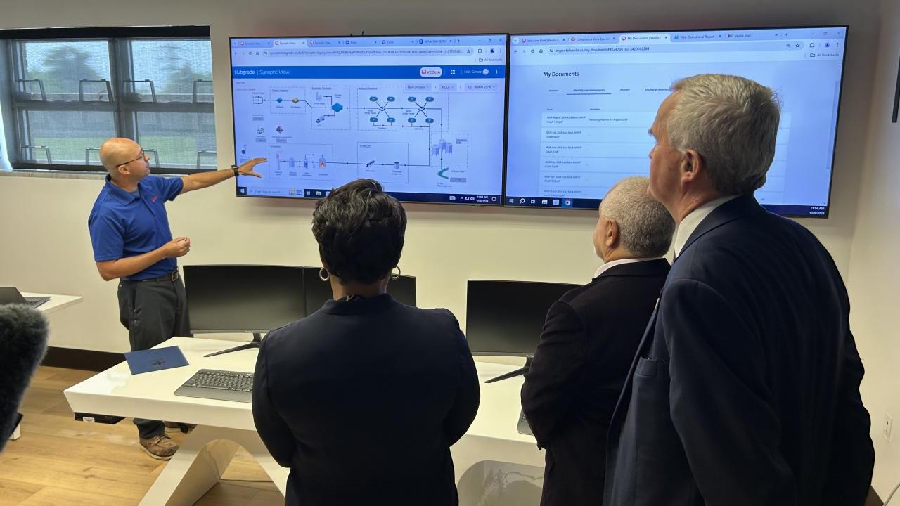 Veolia Project Manager Erick Gomez demonstrates the Hubgrade digital solution in the new control room at New Orleans’ East Bank wastewater treatment plant for, from left to right, New Orleans Mayor LaToya Cantrell, Sewerage and Water Board of New Orleans Executive Director Ghassan Korban and Veolia North America CEO Frédéric Van Heems.