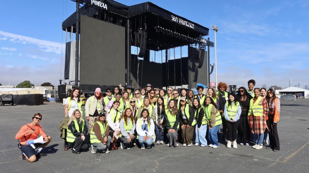 Students posed for a photo in front of the festival's main stage while on their exclusive festival grounds tour.