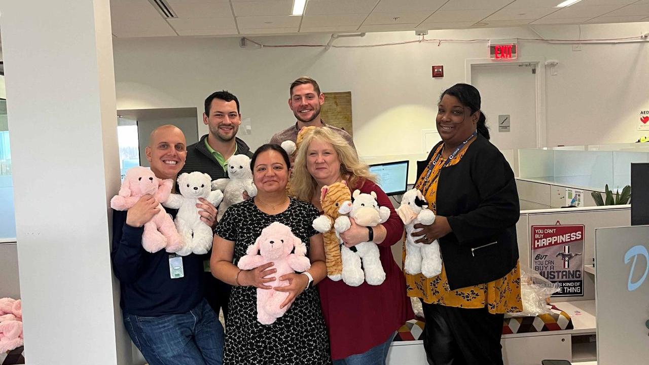 Covia employees pose with teddy bears for charities and hospitals