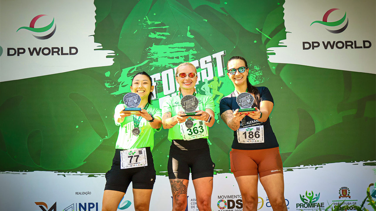 Three Forest Run participants hold awards at the DP World-sponsored event in Santos.