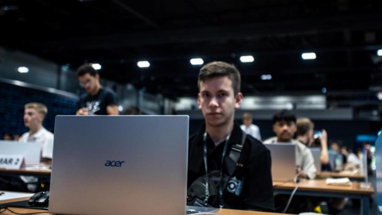 A participant with Acer laptop at IOI 2023