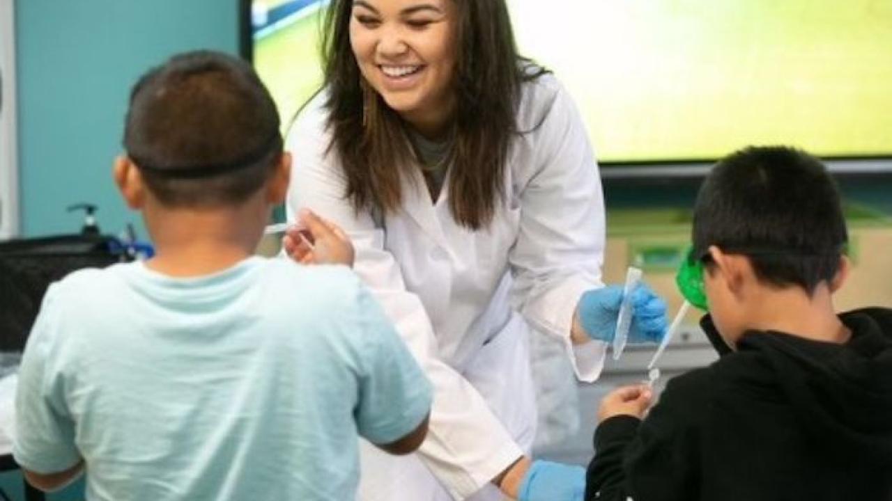 Illumina scientist working with children in a classroom.
