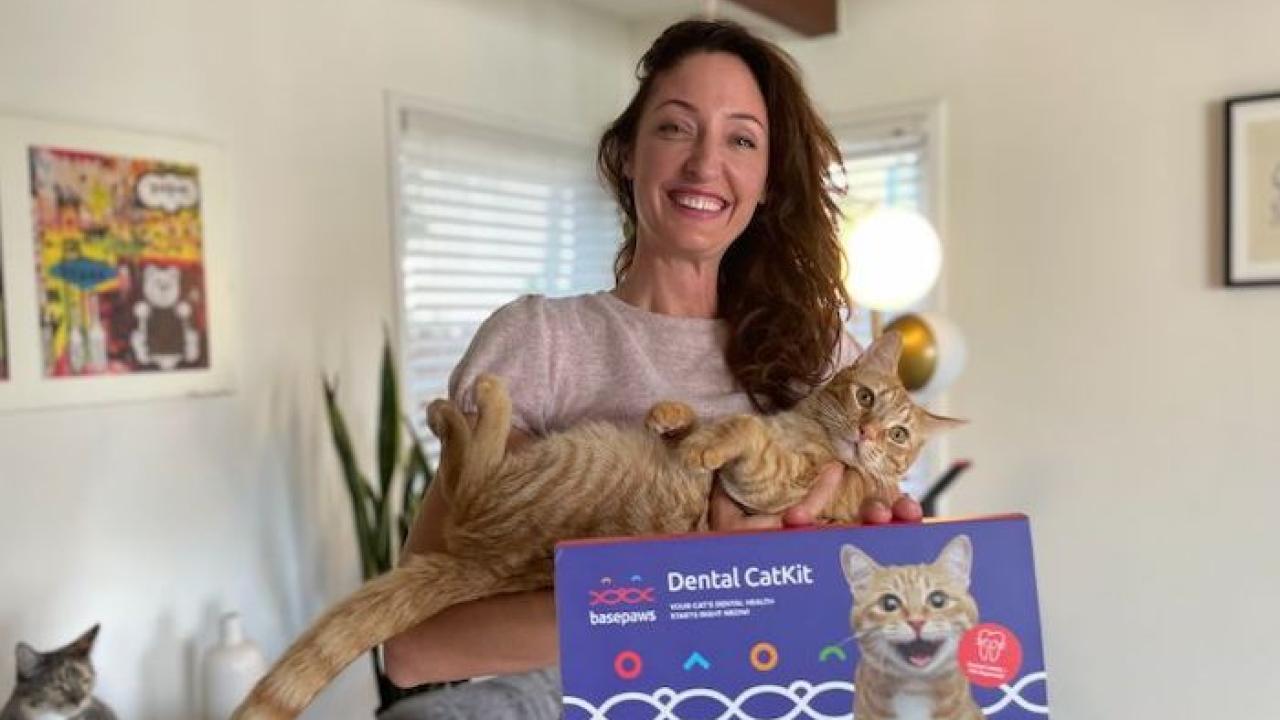 Anna Skaya holding her cat and a Dental CatKit