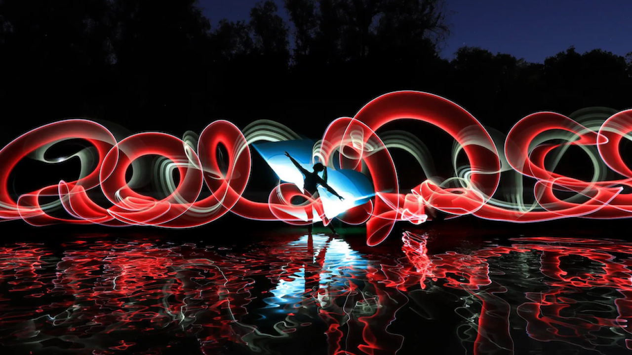 artistic image of red swirls and person in the dark
