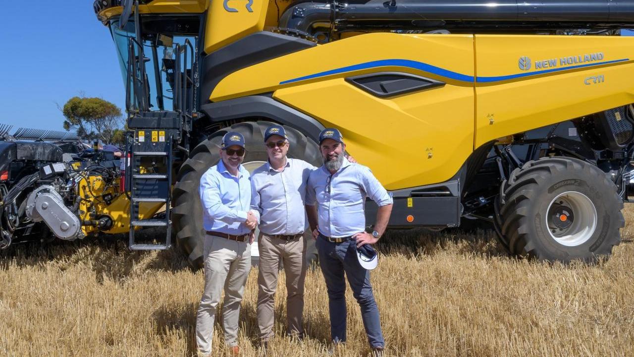 3 people in front of a tractor