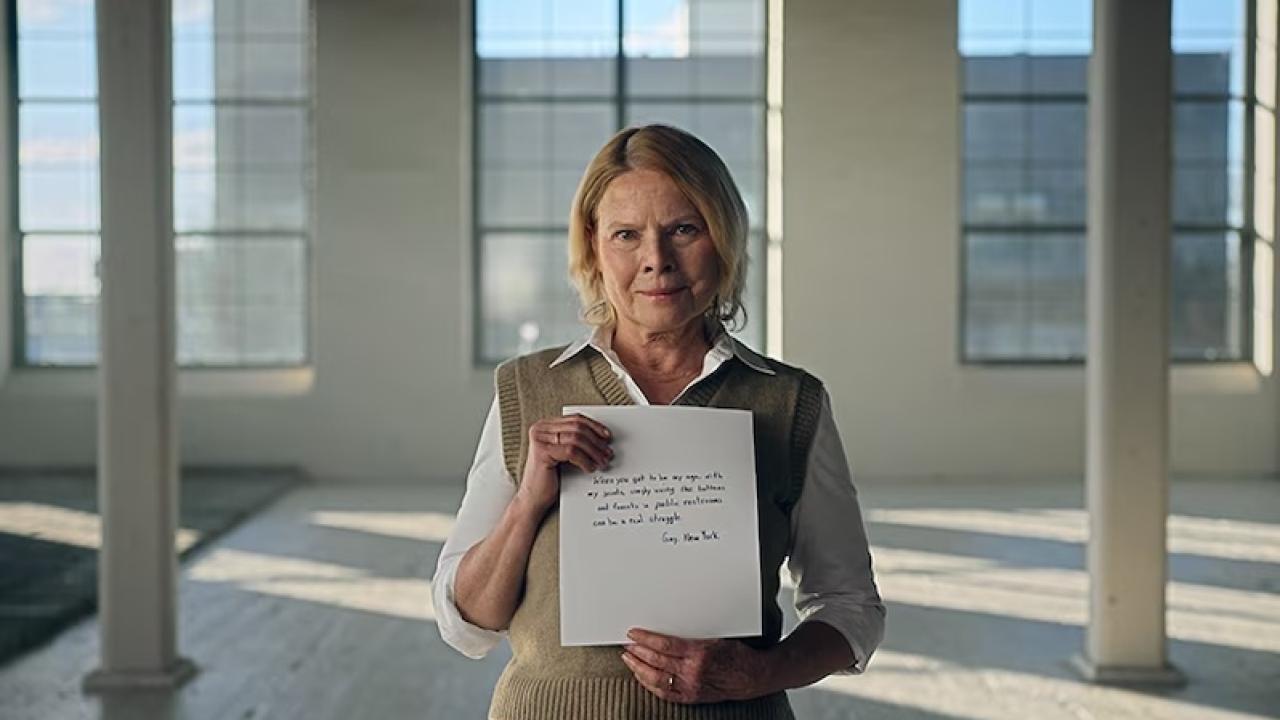 A woman holding a sheet of paper in an office space.