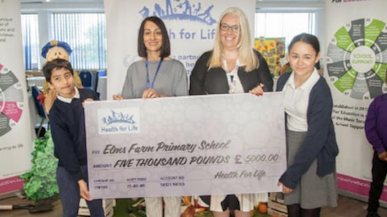 Students and teachers holding a cheque 