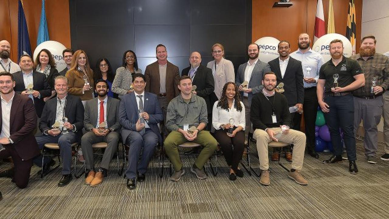 Large group photo of people holding an award