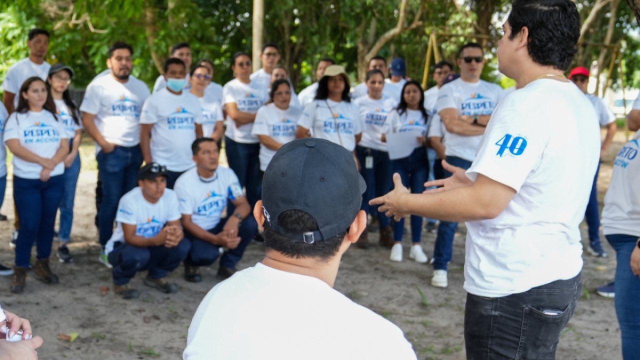 Gildan employees featuring "Respect in Action" and 40th anniversary t-shirts, standing in a circle during a volunteering activity