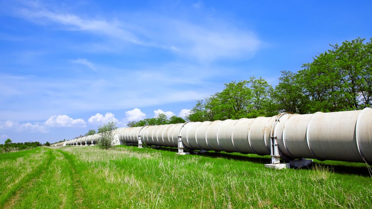 Pipeline in a grassy field with a blue sky