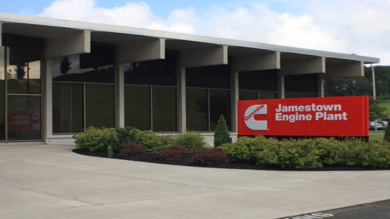 The front of a building with a red and white sign for Jamestown Engine Plant 