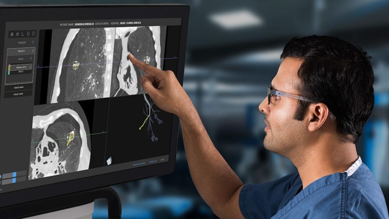 person looking and pointing at computer screen 