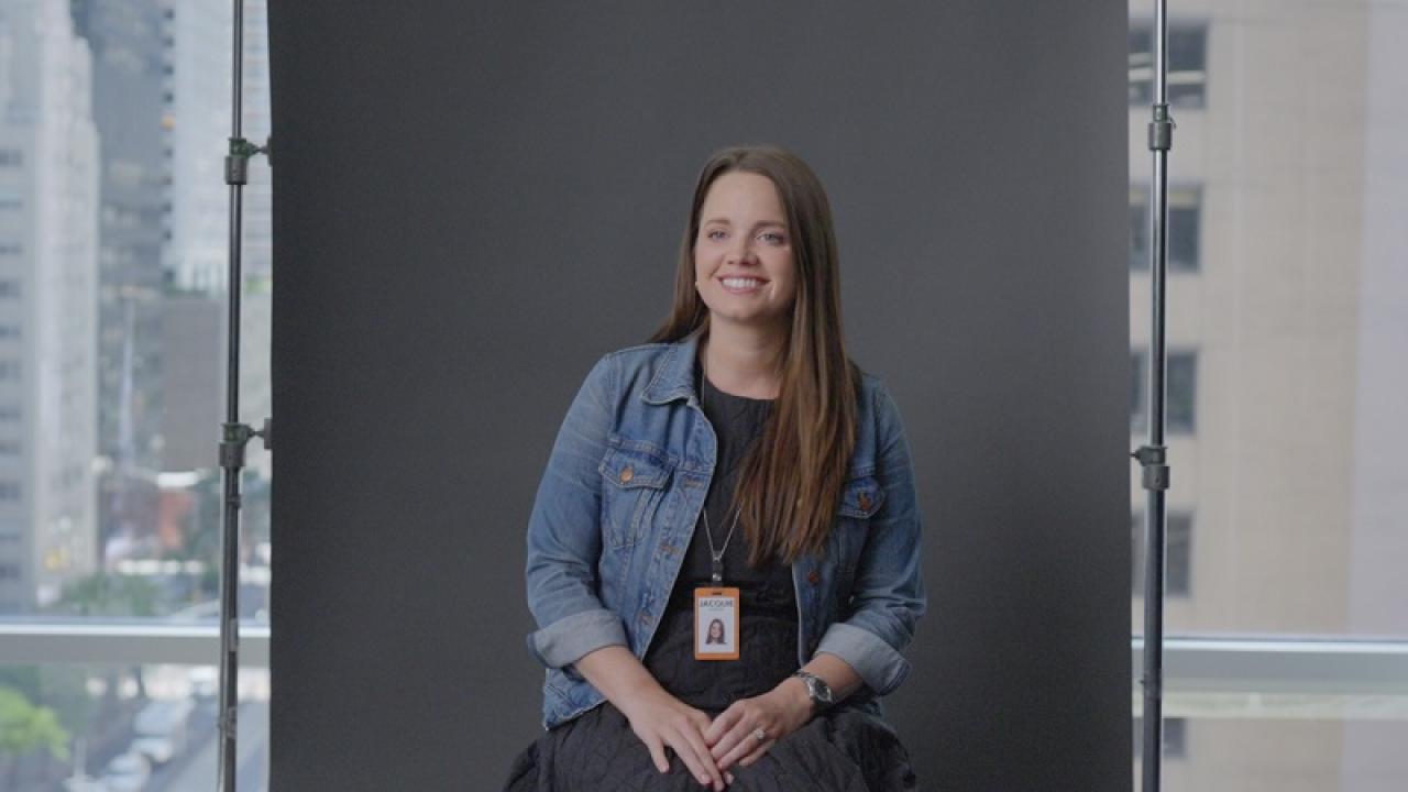 Photo of Jacquie Lennon sat in front of a grey backdrop