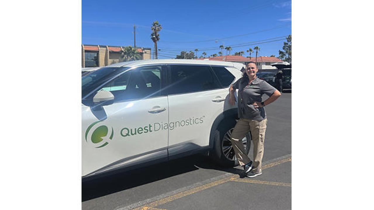 Jamie Croft standing next to a vehicle with Quest Diagnostics logo on the side.