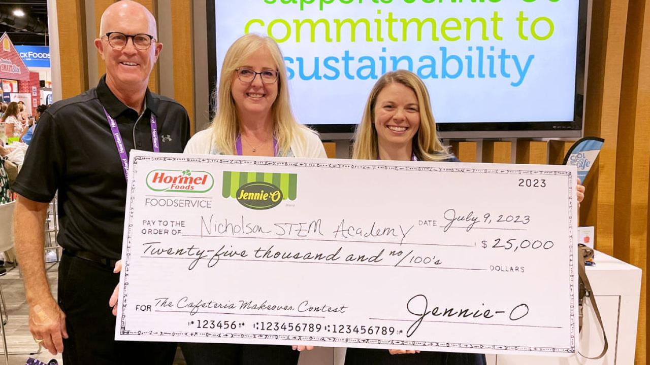Three people holding a large check from Jennie O.