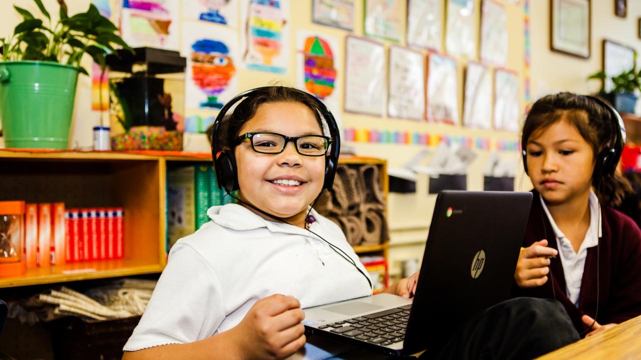 Child with headset using laptop