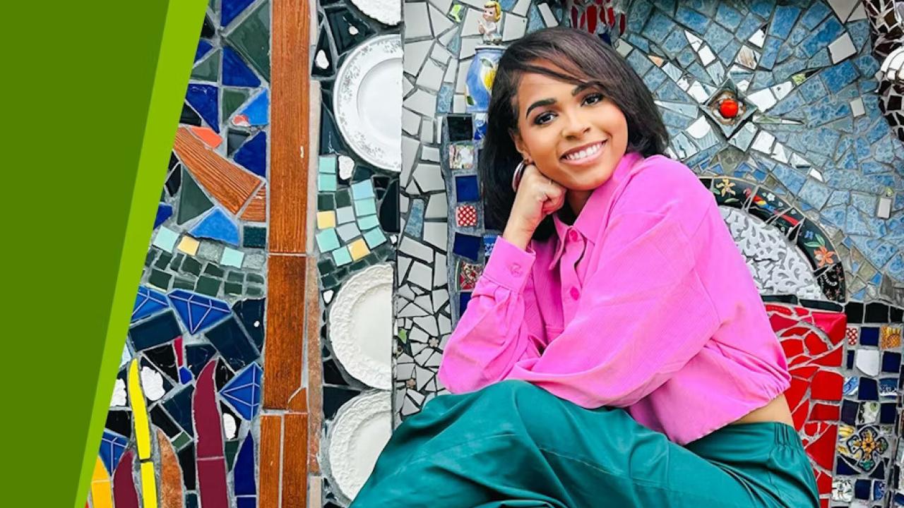 Jordyn Wright posed in front of a mosaic mural.