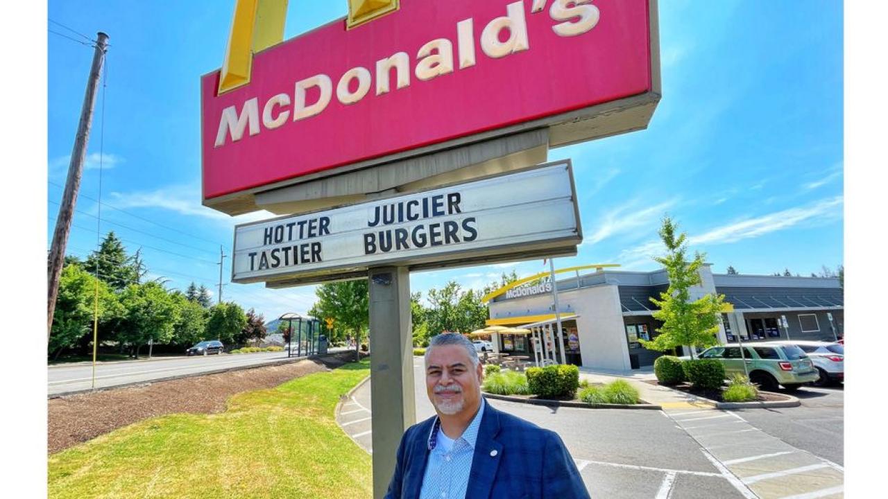 Juan Marquez outside by a McDonalds restaurant sign.