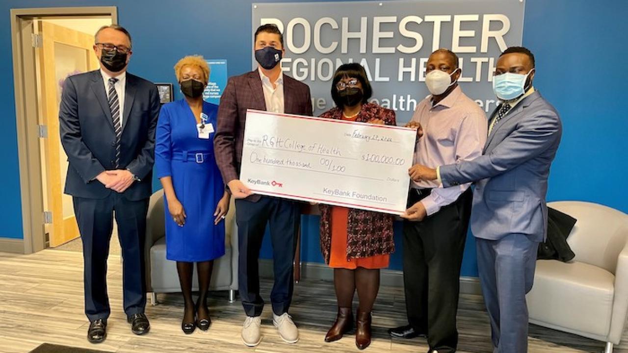 Rochester Regional Health accepts check for $100,00 from KeyBank. 