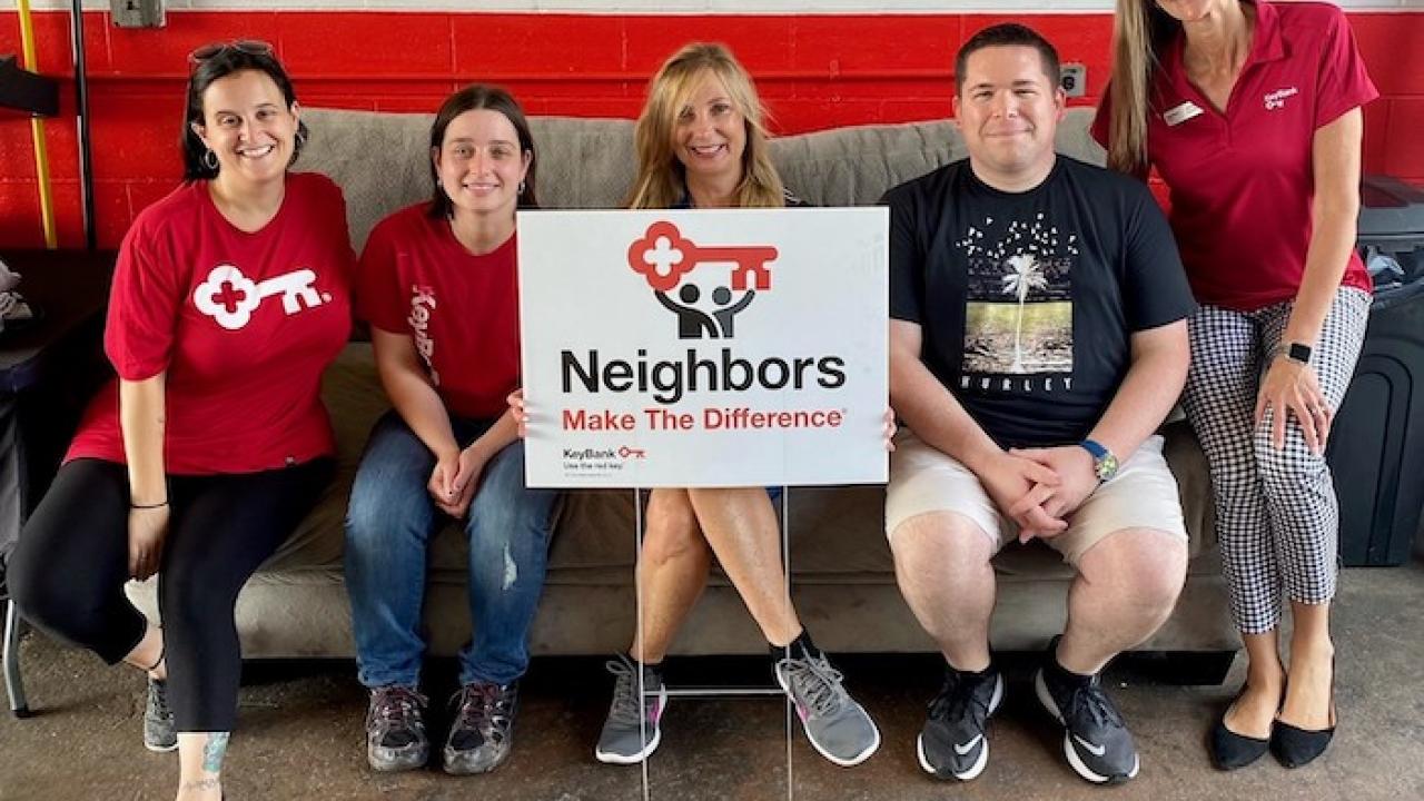 KeyBank volunteers holding a neighbors make the difference sign.