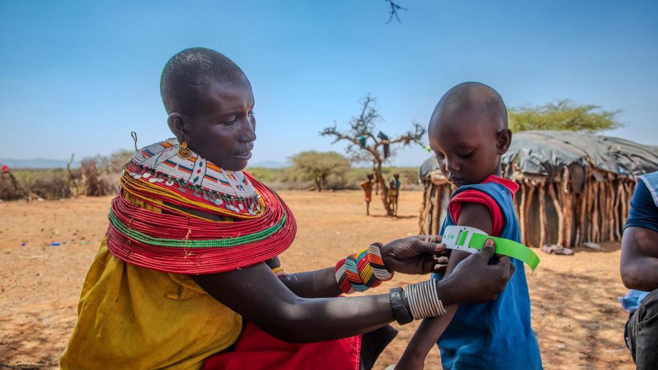 Rashei's mother checks his MUAC measurement after treatment. 