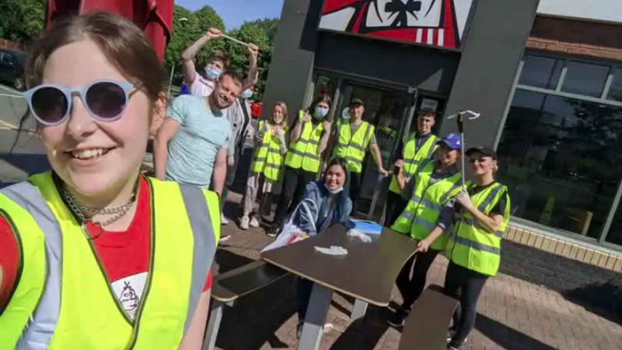 KFC employees in hi-vis vests cleaning up litter