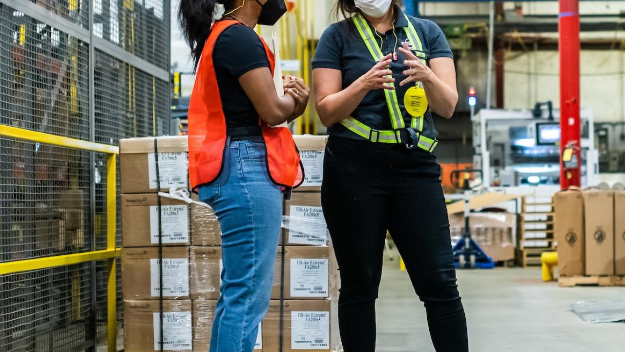 Two female manufacturing employees speaking to each other on the shop floor