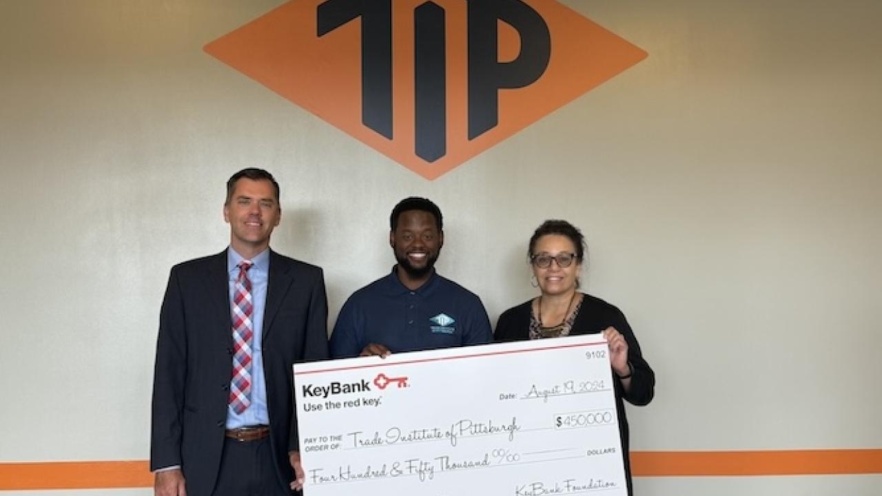 KeyBank and representatives from TIP shown holding a $450,000 grant check.