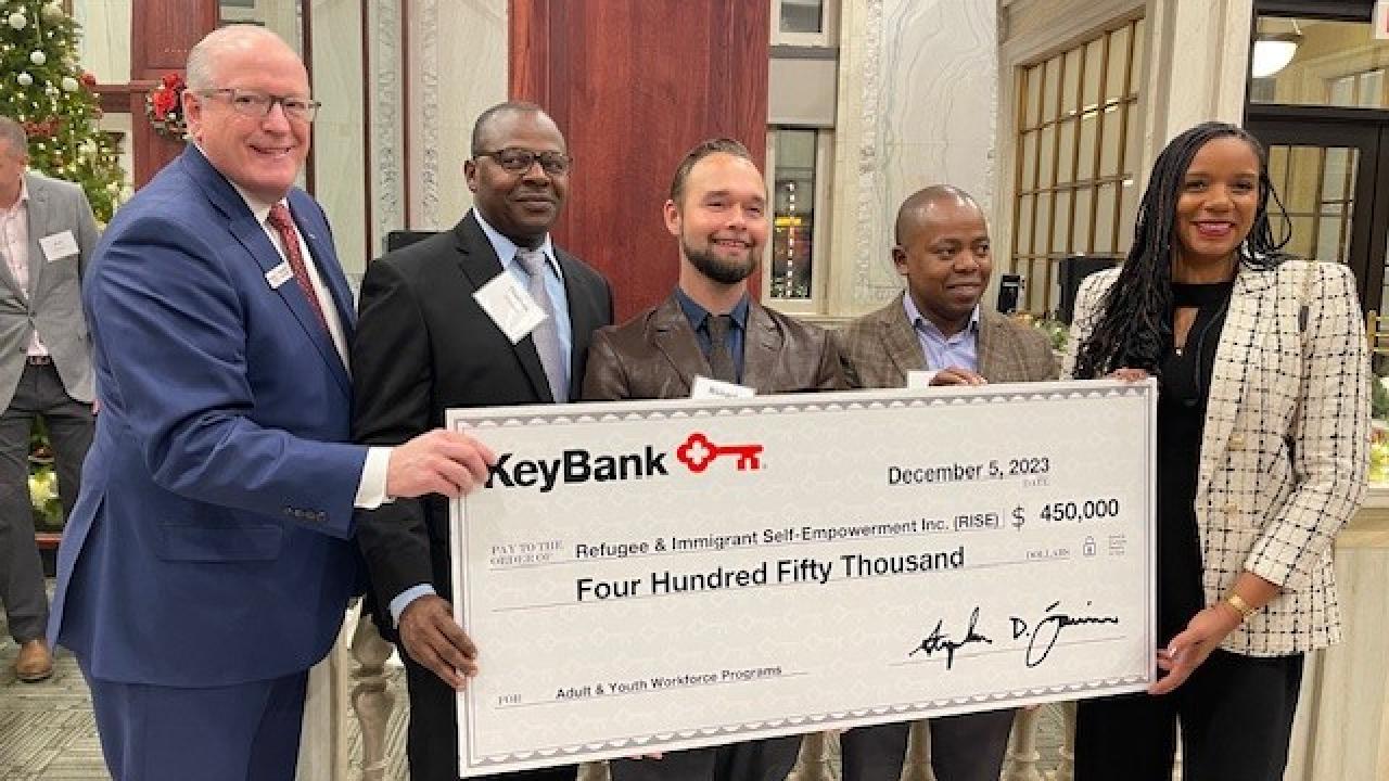 KeyBank and representatives from RISE holding a $450,000 grant check.