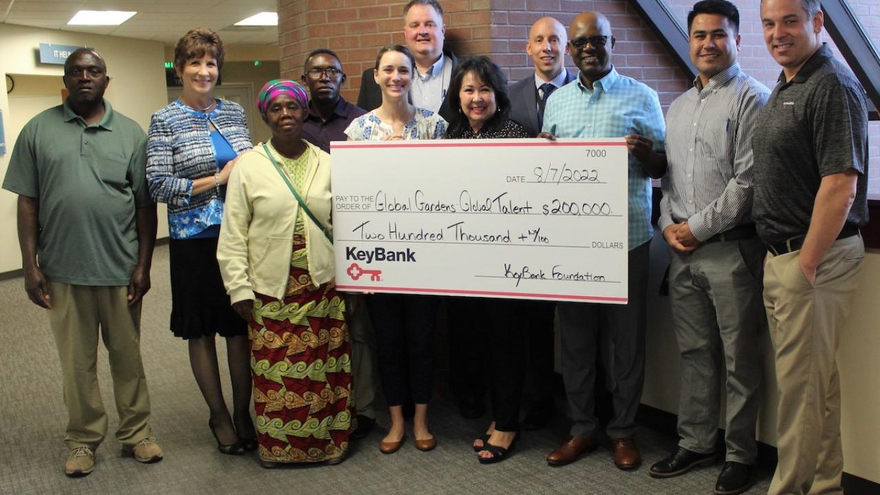 Jannus and KeyBank employees hold a donation check.