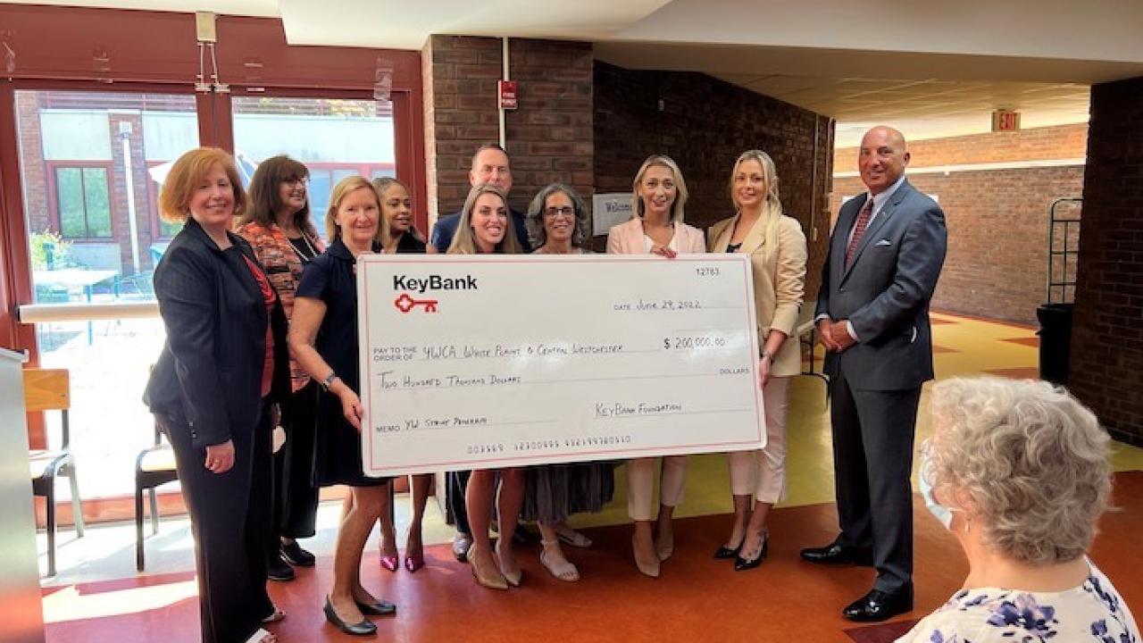 Group of people hold a large KeyBank check
