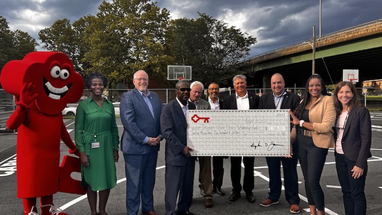 Representatives from KeyBank and Excelsior University shown with a check.