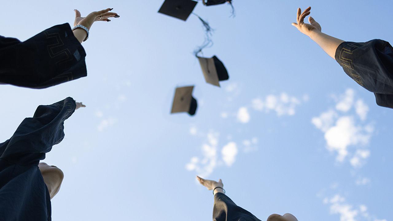 graduates throwing caps in the air