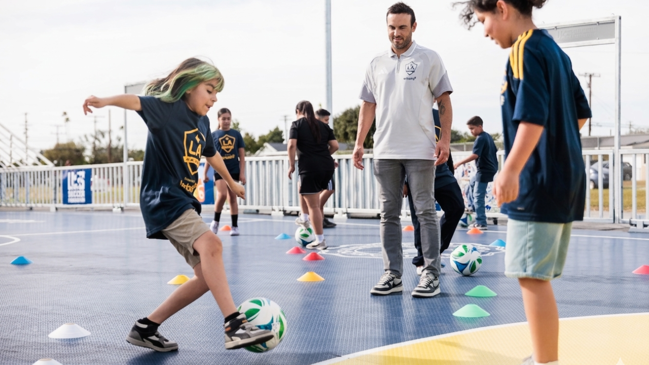 Landon Donovan watching a student practice soccer drills on a mini-pitch.