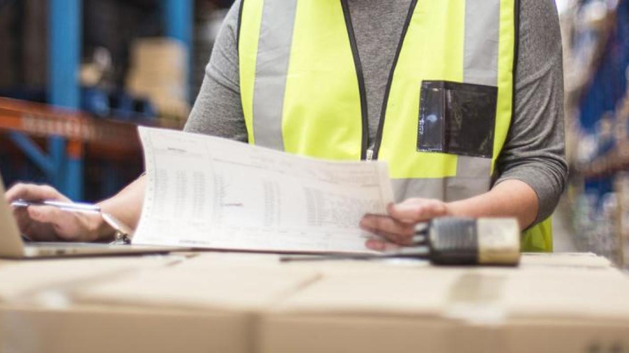 Person wearing a hi-vis jacket working on a laptop