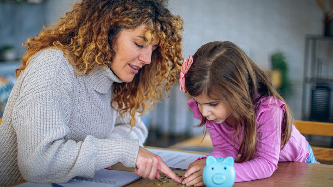 Woman and little girl discussing a lesson about money