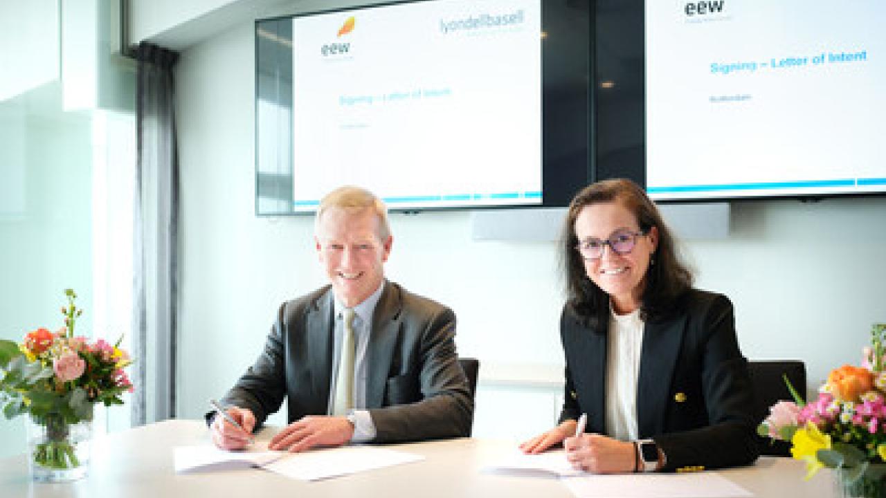 Two people signing contracts