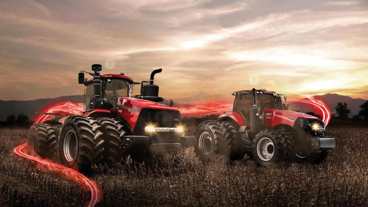 Two red tractors in a farm field, setting sun in the distance and red digital lights behind them.