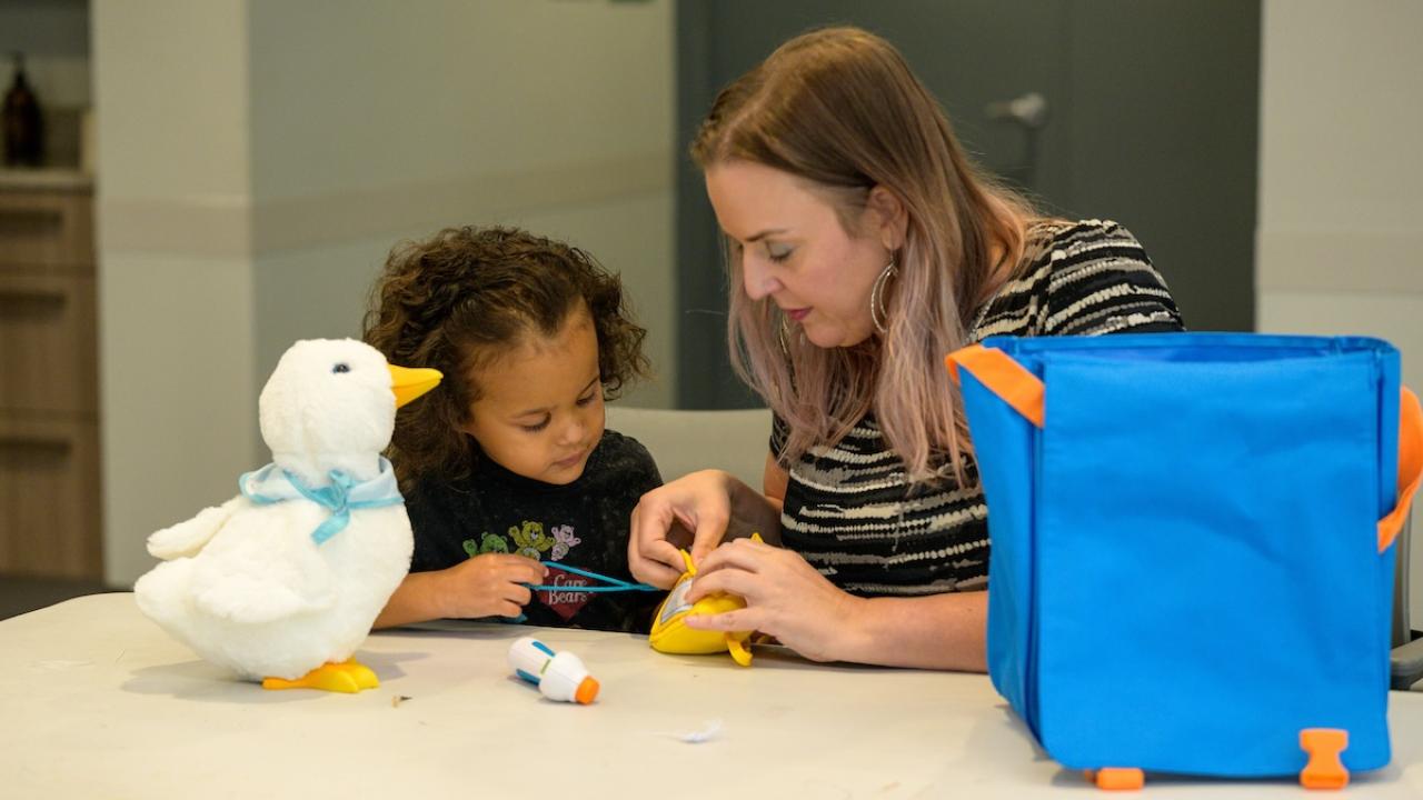 adult with child and stuffed toy duck