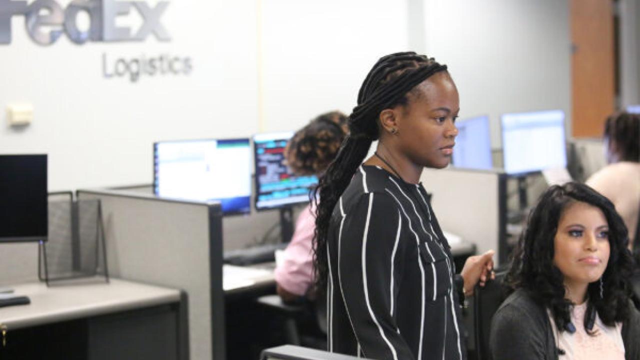 two women in a FedEx Logistics office looking off-camera