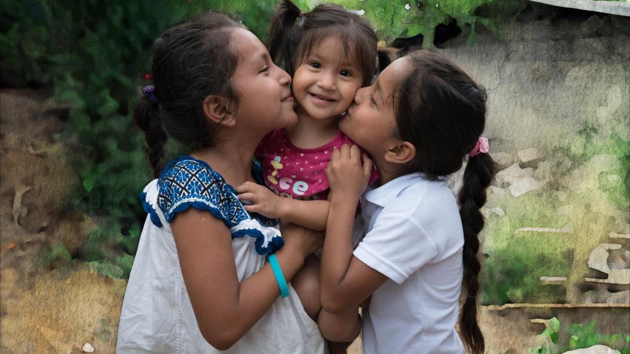 young girls hugging and kissing cheeks